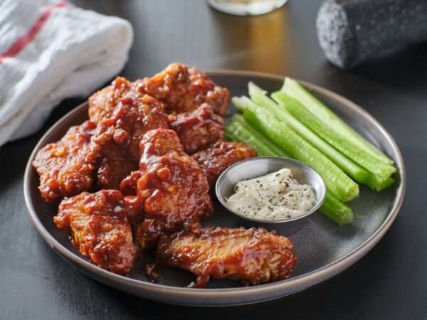 boneless chicken wings covered in honey garlic bbq sauce with ranch and celery